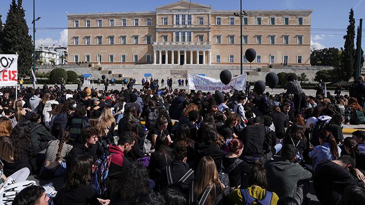 Para pengunjuk rasa melakukan aksi demonstrasi, setelah tabrakan di mana dua kereta bertabrakan di dekat kota Yunani Larissa, di depan gedung parlemen di Athena, Yunani, 3 Maret 2023. Plakat bertuliskan 