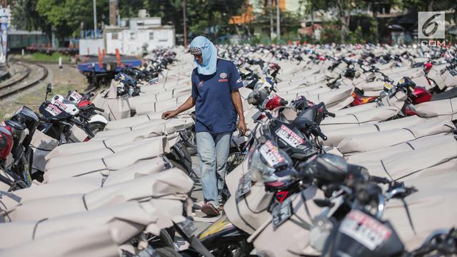 Pekerja melewati motor pemudik sebelum dikirim dengan kereta api di Stasiun Jakarta Gudang, Selasa (28/5/2019). 