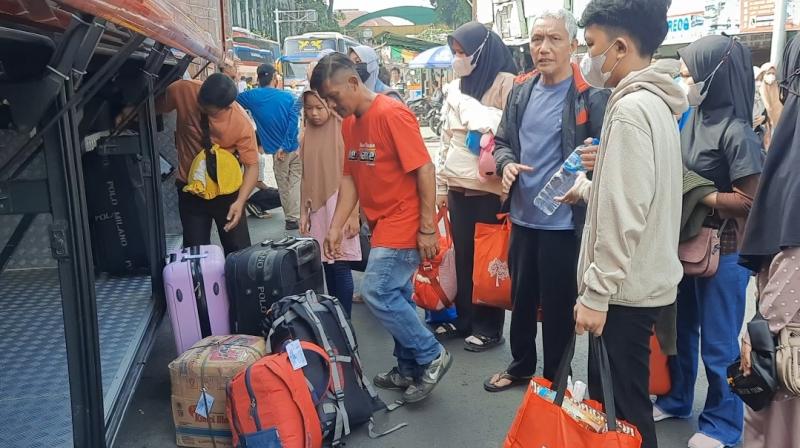 Pemudik dengan sejumlah barang bersiap naik ke bus yang diberangkatkan dari Terminal Induk Kota Bekasi, Jawa Barat pada Rabu (12/4/2023).