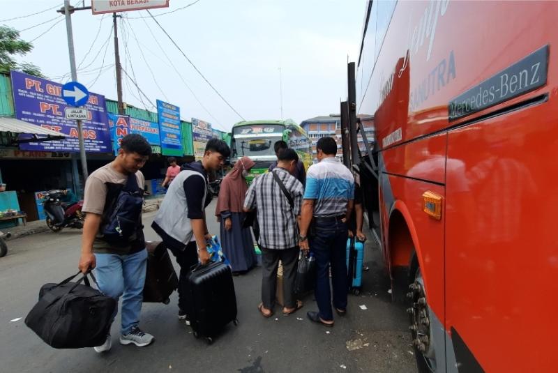 Penumpang hendak menaikan barang ke atas bus yang akan berangkat dari Teminal Induk Kota Bekasi, Jawa Barat, Rabu (24/5/2023).