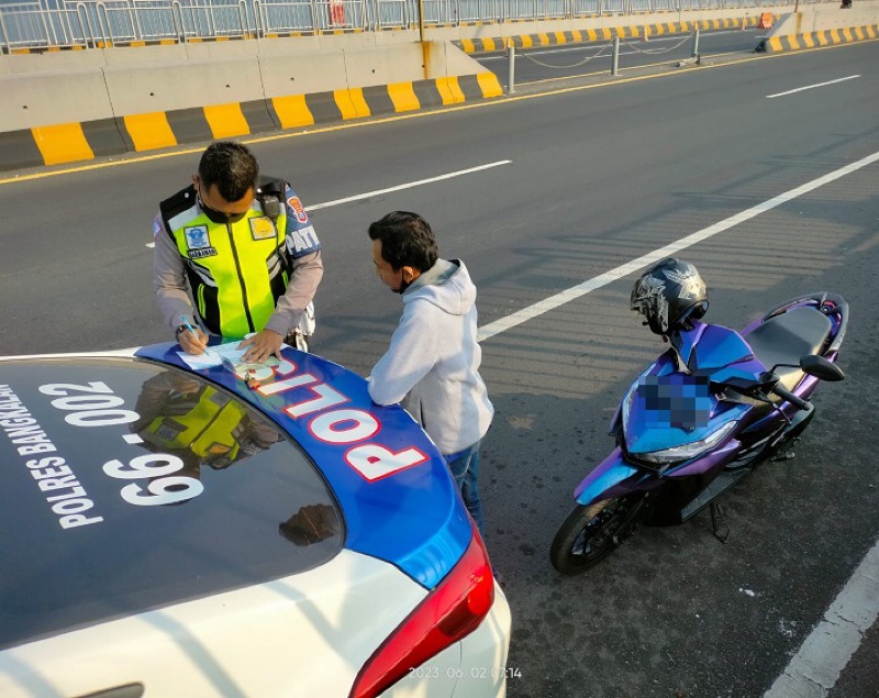 Polres Bangkalan melakukan tilang terhadap 8 kendaraan roda 2 yang melintas di area Suramadu di jalur kendaraan roda 4, Jumat (2/6/2023) pagi. Foto: istimewa.