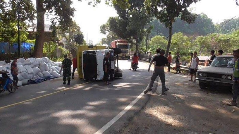 Truk muatan pupuk terguling setelah dihantam mobil pikap. Foto: istimewa.