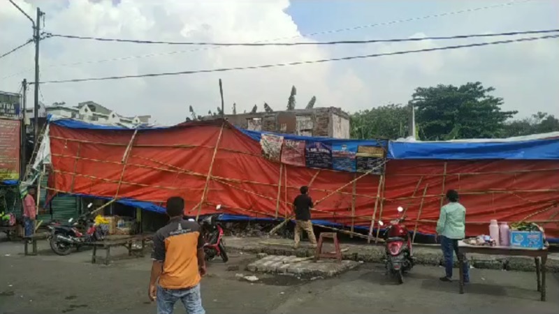 Tenda sementara khusus penjualan tiket bus Sumatera, terbang dihempas angin kencang tepat di depan bangunan yang terbakar, Kamis (15/6/2023) siang.