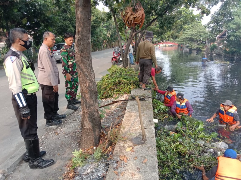 Personel Polsek Bekasi Timur bersama Bhabinkamtibmas Bekasi Jaya dan 3 Pilar melaksanakan kegiatan pengamanan bersih-bersih sampah dan pengerukan lumpur di Kali Jalan Baru Underpass, Kelurahan Duren Jaya.