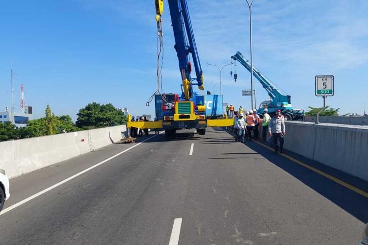 Aparat kepolisian dan petugas jalan tol melakukan evakuasi terhadap kontainer yang alami kecelakaan tunggal di ruas Jalan Tol Reformasi KM 5, Kota Makassar, Sulawesi Selatan (Sulsel), pada Selasa (8/8/2023) siang.(dokumentasi Satlantas Polrestabes Makassar)