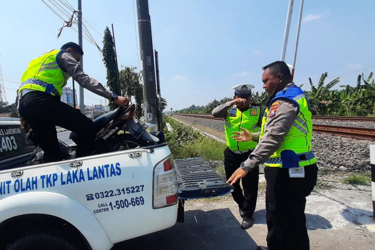 Polisi saat melakukan evakuasi sepeda motor yang tertabrak kereta api komuter di jalur perlintasan Desa Plosowahyu, Kecamatan/Kabupaten Lamongan, Jawa Timur, Rabu (9/8/2023).(Dok. istimewa)