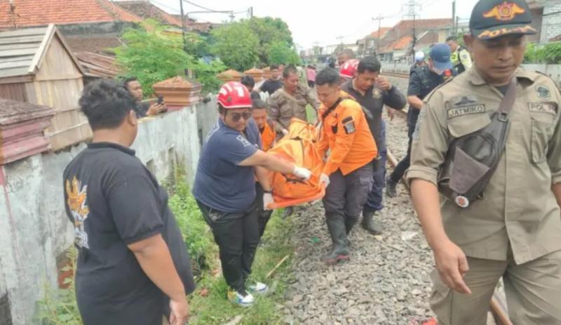 Petugas mengevakuasi jenazah pemuda 21 tahun yang tertabrak kereta api di perlintasan Jalan Tambak Mayor Utara Surabaya, Sabtu (16/3/2024). (Ist)