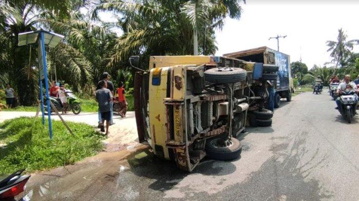 Mobil box pembawa air mineral kemasan terguling dihantam kereta api di perlintasan tanpa palang Desa Sei Alim, Kecamatan Sei Dadap, Kabupaten Asahan, Jumat (19/4/2024). (Ist)