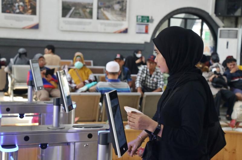 Penumpang kereta api melakukan boarding dengan sistem Fece Recognition di Stasiun Pasar Senen. (Foto:dok KAI)
