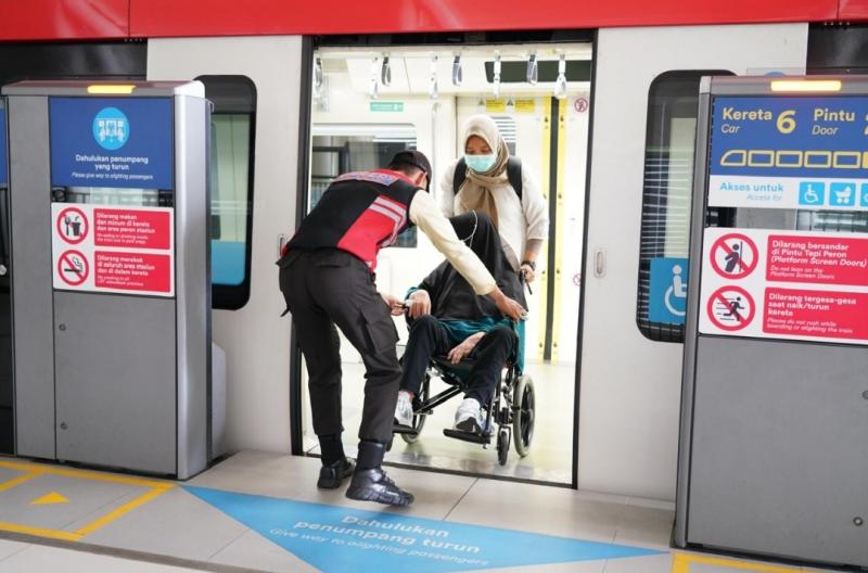 Petugas membantu penumpang LRT Jabodebek dengan alat bantu berupa kursi roda. (Foto:Dok.KAI LRT Jabodebek)
