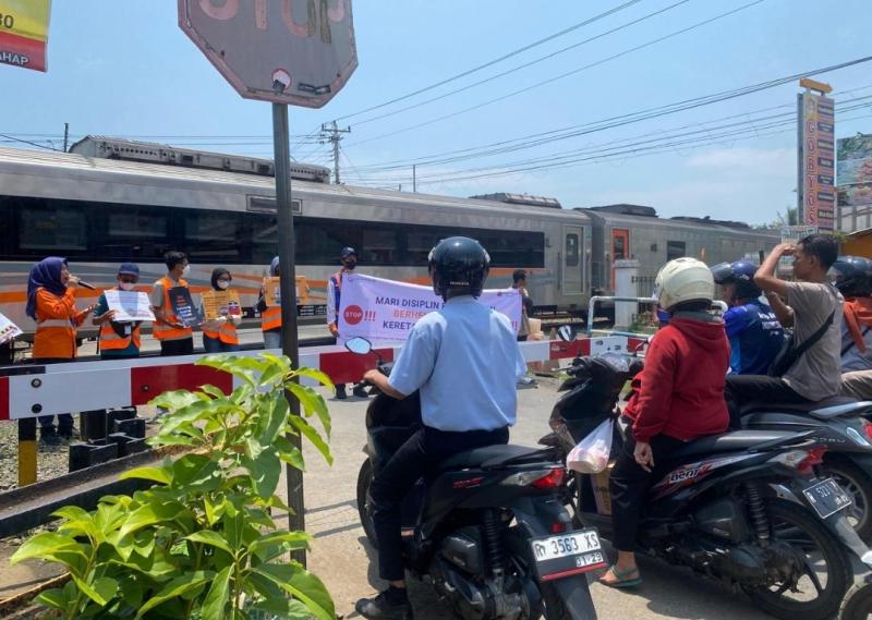 Petugas KAI dari Daop 5 Purwokerto bersama railfans melakukan sosialisasi di perlintasan sebidang di Kroya pada Sabtu (9/11/2024).