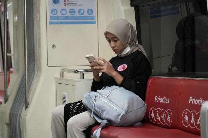 Penumpang LRT Jabodebek dengan menggunakan pin ibu hamil tampak duduk di kursi prioritas sebagai pelayanan untuk kenyamanan penumpang dalam menggunakan moda transpotasi tersebut.(ist)