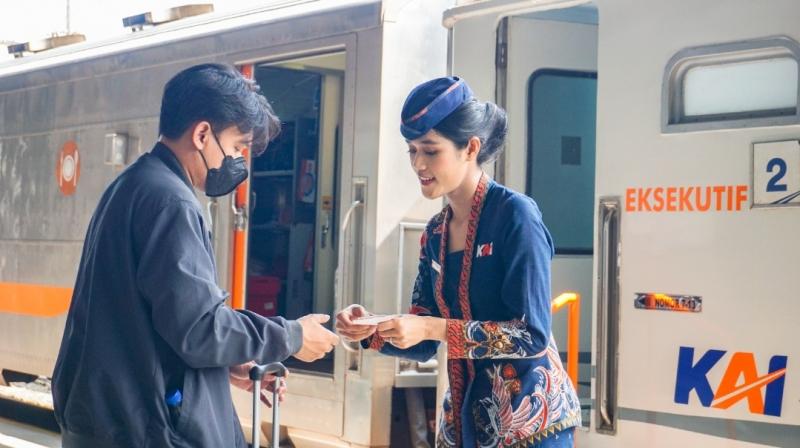 Petugas prami atau pramugari kereta api saat bertugas memberikan bantuan kepada penumpang. (Ilustrasi:KAI)