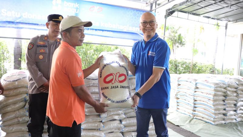 Presiden Direktur PT Bank Jasa Jakarta, Leo Keosmanto (kanan), saat menyerahkan bantuan beras dalam kegiatan bakti sosial di Jakarta, Sabtu (15/3/2025). (Dok. Bank Saqu)