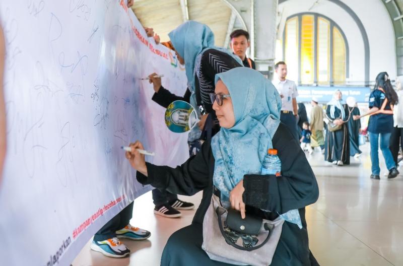Masyarakat penumpang KA menandatangi seruan saat sosialisasi pencegahan kekerasan dan pelecehan seksual yang dilakukan KAI Daop 1 Jakarta di Stasiun Jakarta Kota, Ahad (27/4).