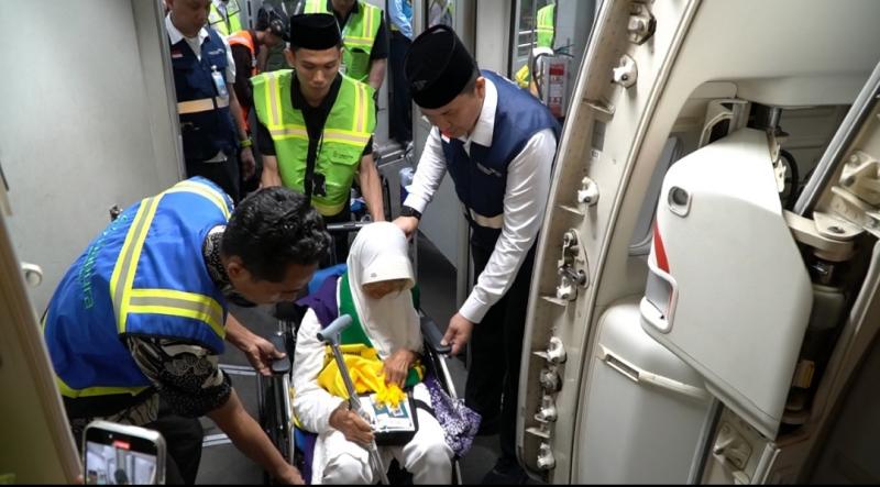 Petugas melayani penumpang jemaah haji di pesawat