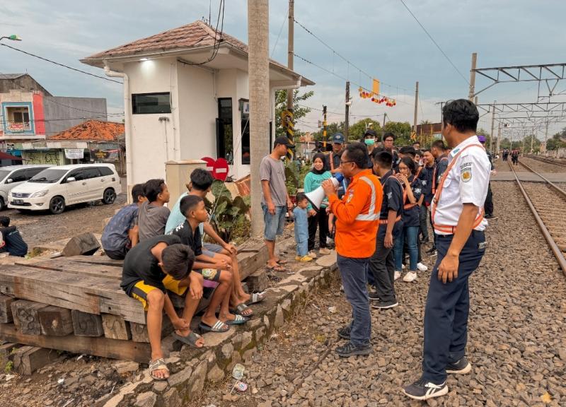 Petugas KAI Daop 1 Jakarta bersama komunitas railfans melakukan kampanye edukatif untuk mencegah kecelakaan di jalur rel di perlintasan sebidang JPL 81 Bekasi, Sabtu (14/6).