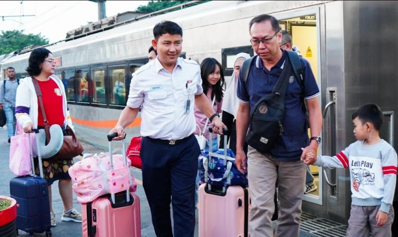 Petugas KAI Daop 1 Jakarta bantu bawakan barang penumpang KA Sembrani yang mengalami keterlambatan kedatangan di Stasiun Gambir, Senin (23/6), sebagai bentuk pelayanan dan permohonan maaf.