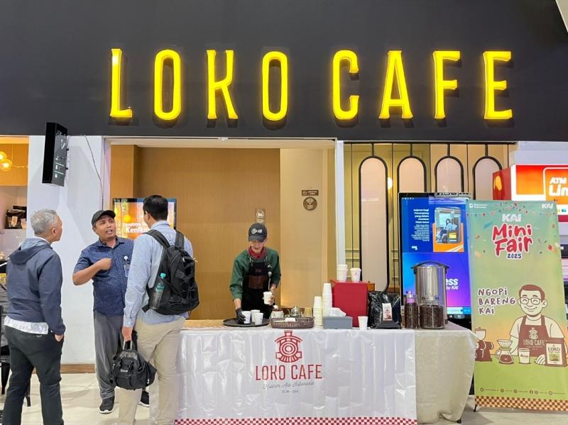 Penumpang menikmati sajian kopi gratis dari Loko Café dalam gelaran KAI Mini Fair di Stasiun Gambir, Jumat (11/7/2025).